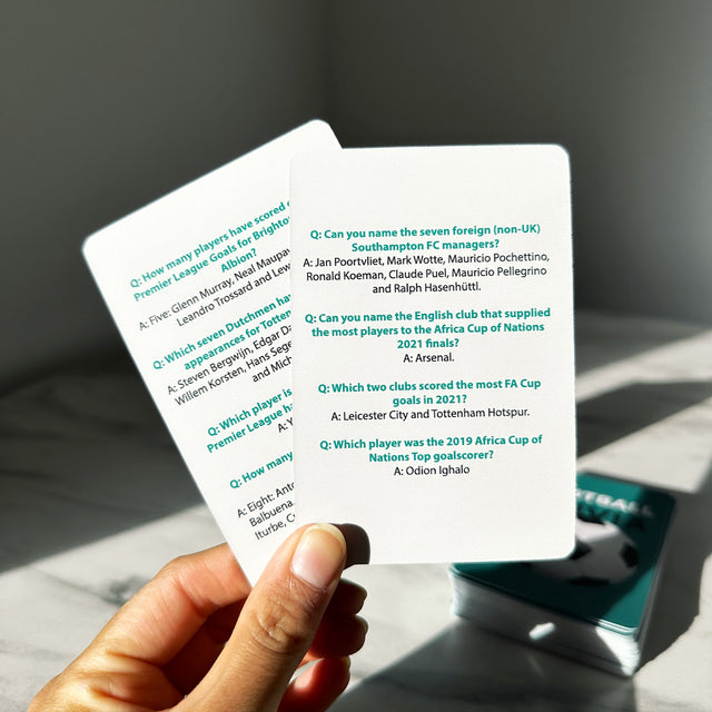 Hand Holding Football Trivia Cards by Pikkii