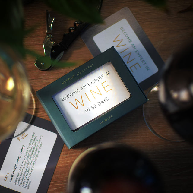 Become an expert in wine in 90 days slide box by Pikkii on side table with accessories - the perfect gift for wine lovers