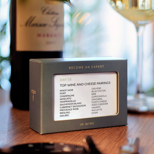 Become an expert in wine in 90 days slide box by Pikkii on kitchen countertop with wine bottle and wine glass - top wine and cheese pairings day 58