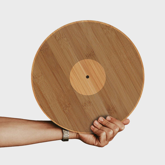 Hand holding a 12" Inch vinyl record shaped bamboo wooden Chopping Board