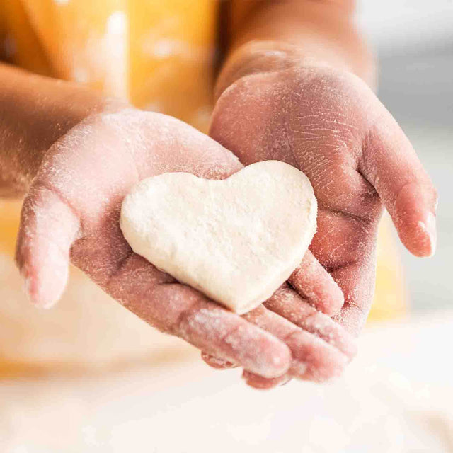 Man holding Heart Shaped Cookie Dough with both hands 