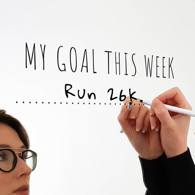 Woman writing her weekly fitness goals on a mirror