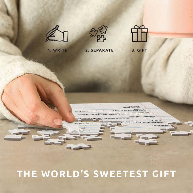 hand placing jigsaw puzzle piece together to reveal heartwarming message on table