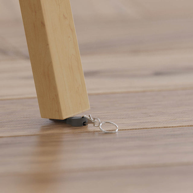 WonKey Keyring - Fixes Wobbly Tables - under table leg on wooden flooring background