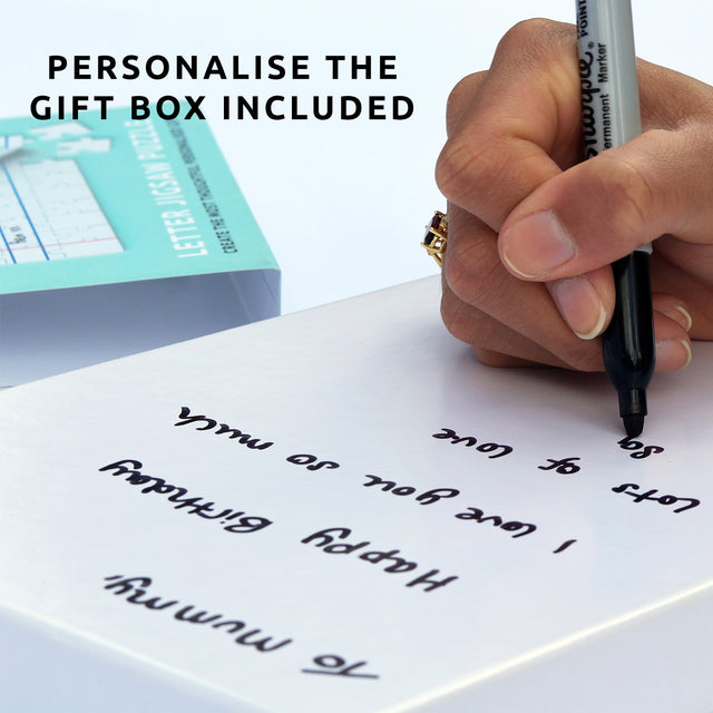 Hand writing on plain gift box of Pikkii's personalised letter jigsaw puzzle gift with permanent market