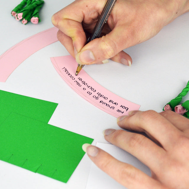 Hand writing a personalised message on paper flowers