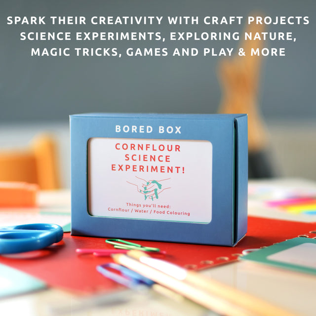 Bored box by Pikkii on table with craft tools - includes craft projects, science experiments, exploring nature, magic tricks, games and play, and more