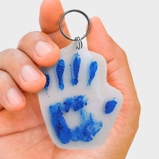 Close up of hand holding blue Pikkii Hand Print Shrink Keyring