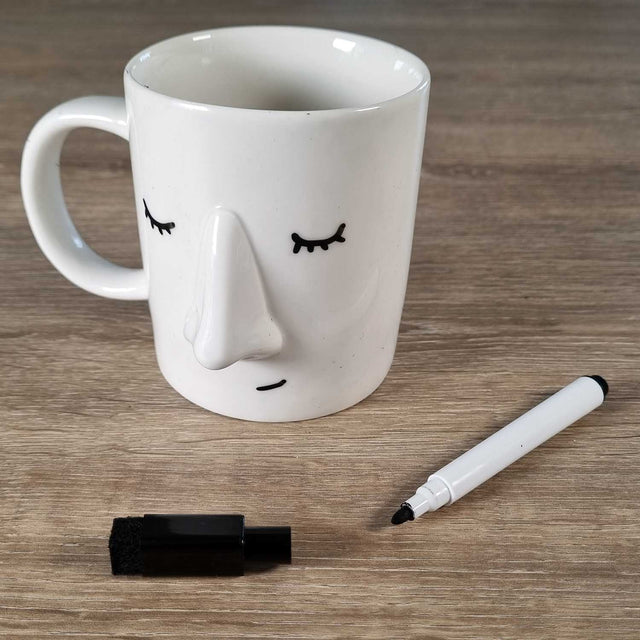 Coffee Mug with a sleepy face drawn onto it