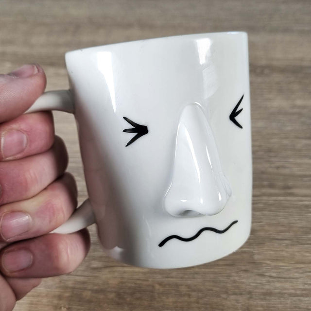 Coffee mug with a stressed mood face drawn onto it