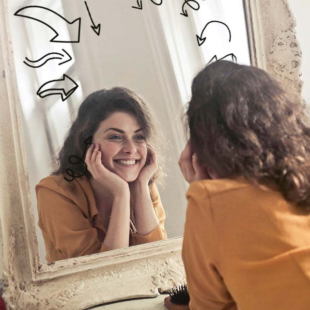 woman smiling in front of mirror with all about me decals