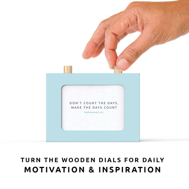 Hand turning the wooden dial to scroll through the motivational quotes scroll box, showing the Muhammad Ali quote "Don't count the days. Make the days count".