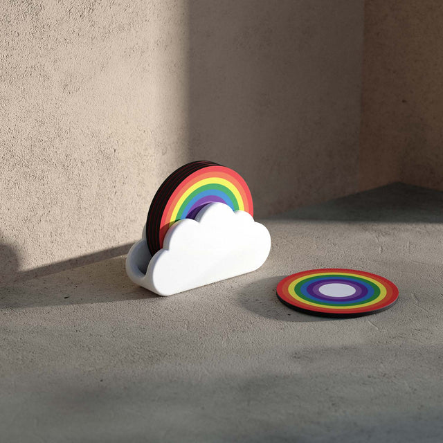 Nesting wooden rainbow coasters in a white ceramic cloud holder