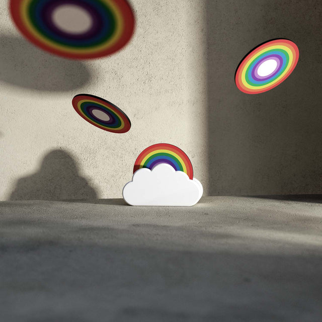 Nesting wooden rainbow coasters in a white ceramic cloud holder with coasters flying in the air